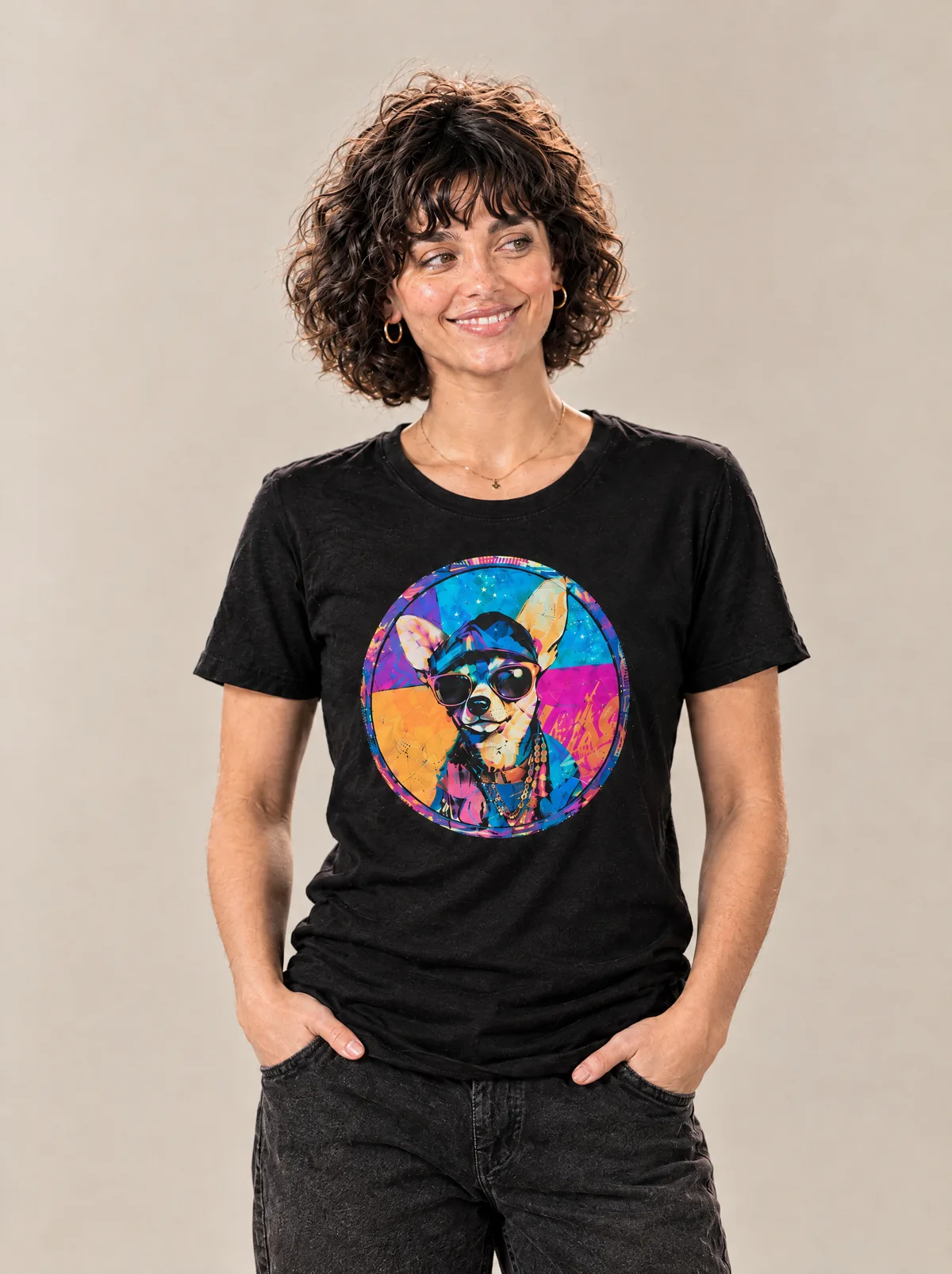 A young woman with curly hair in a black tee printed with a pop-art chihuahua in sunglasses, in a sunny photo studio